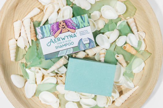 Aerwyna solid shampoo bar in a wooden bowl with sea shells — plant-based sulfate-free haircare